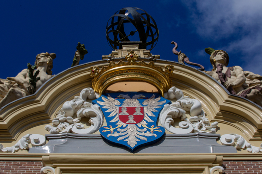 View of the ornate coat of arms featuring a double headed eagle and classical statues on the facade of Castle Groeneveld in Baarn Utrecht Netherlands.