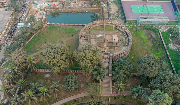 Aerial view of the ancient brick structure standing proudly amidst the verdant landscape framed by a tranquil pond and tennis court Munshiganj Bangladesh. Aerial view of the ancient brick structure standing proudly amidst the verdant landscape framed by a tranquil pond and tennis court Munshiganj Bangladesh.