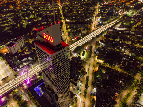 Aerial view of the illuminated Hotel Riu Plaza Guadalajara and the glowing Matute Remus Bridge surrounded by city lights at night in Guadalajara Jalisco Mexico. Aerial view of the illuminated Hotel Riu Plaza Guadalajara and the glowing Matute Remus Bridge surrounded by city lights at night in Guadalajara Jalisco Mexico.