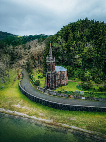 Aerial view of the gothic Capela de Nossa Senhora das Vit&oacute;rias standing elegantly against the backdrop of lush green hills Furnas Portugal.