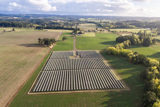 Aerial view of a solar farm situated in the middle of green agricultural fields and rural landscape in Woodburn Oregon United States. Aerial view of a solar farm situated in the middle of green agricultural fields and rural landscape in Woodburn Oregon United States.