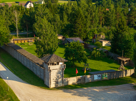 Aerial view of the wooden fortifications of Voruta castle with a watchtower palisade walls and green courtyard surrounded by lush forest in Anyksciai Utenos apskritis Lithuania.