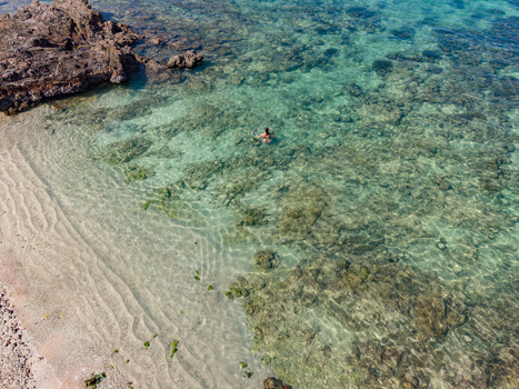 Aerial view of a lone swimmer gliding through the turquoise waters near the rocky shore a serene escape captured from above Siqirah Yemen. Aerial view of a lone swimmer gliding through the turquoise waters near the rocky shore a serene escape captured from above Siqirah Yemen.