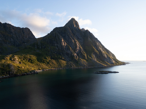 Aerial view of the sharp mountain peaks of Tangstad overlooking the calm sea during golden hour in Leknes Nordland Norway. Aerial view of the sharp mountain peaks of Tangstad overlooking the calm sea during golden hour in Leknes Nordland Norway.