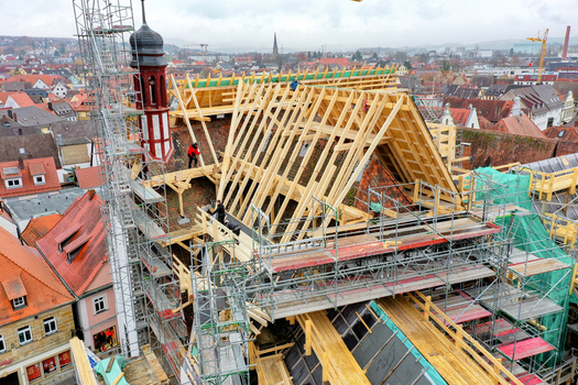 Aerial view of Rathaus Forchheim under renovation with new wooden roof trusses scaffolding and workers overlooking the historic rooftops of Forchheim Bayern Germany. Aerial view of Rathaus Forchheim under renovation with new wooden roof trusses scaffolding and workers overlooking the historic rooftops of Forchheim Bayern Germany.