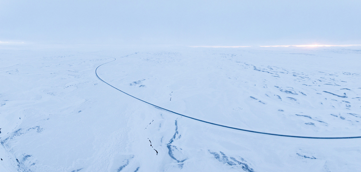 Aerial view of a winding road cutting through a vast snow covered landscape in Egilsstadir Mulathing Iceland. Aerial view of a winding road cutting through a vast snow covered landscape in Egilsstadir Mulathing Iceland.