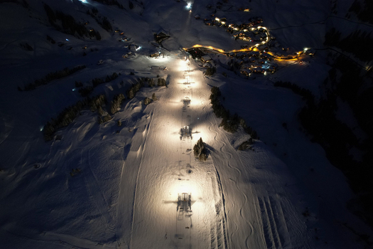 Aerial view of Les Crosets ski resort at night with illuminated slopes and chairlift towers in the snowy mountains of Val d Illiez Valais Switzerland. Aerial view of Les Crosets ski resort at night with illuminated slopes and chairlift towers in the snowy mountains of Val d Illiez Valais Switzerland.