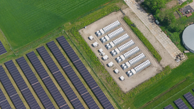 Aerial view of a solar farm with rows of photovoltaic panels and a battery energy storage system in a rural landscape in Wanneperveen Overijssel Netherlands.