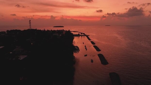 Aerial view of Kendhoo island at sunset with boats in the harbor Maldives. Aerial view of Kendhoo island at sunset with boats in the harbor Maldives.