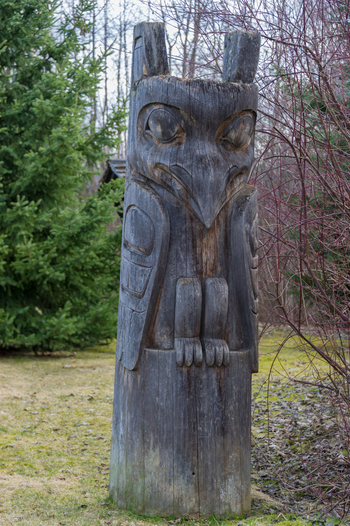 View of a weathered wooden totem pole with intricate carvings at Ksan Campground in Ksan British Columbia Canada. View of a weathered wooden totem pole with intricate carvings at Ksan Campground in Ksan British Columbia Canada.