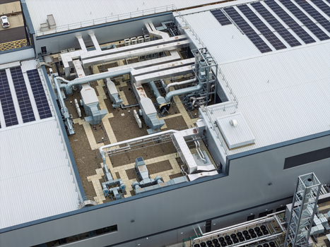 Aerial view of a data center roof featuring complex HVAC systems ventilation ducts and solar panels in the United Kingdom.