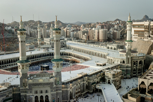 Aerial view of Masjid al Haram with its towering minarets and the Kaaba surrounded by the expansive white marble courtyard and urban architecture of Makkah Makkah Province Saudi Arabia. Aerial view of Masjid al Haram with its towering minarets and the Kaaba surrounded by the expansive white marble courtyard and urban architecture of Makkah Makkah Province Saudi Arabia.