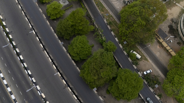 Aerial view of Lagos Island featuring a multi lane highway bridge surrounded by lush green trees and urban infrastructure Lagos Lagos Nigeria. Aerial view of Lagos Island featuring a multi lane highway bridge surrounded by lush green trees and urban infrastructure Lagos Lagos Nigeria.