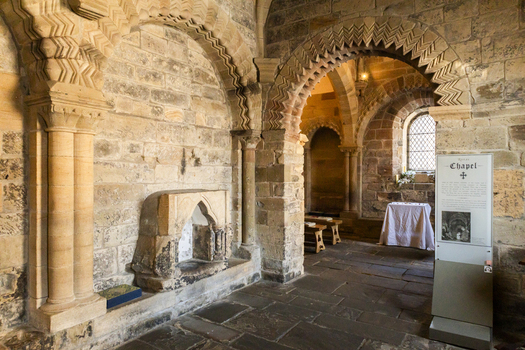 View of the historic Norman chapel interior with intricate chevron patterned stone arches and weathered masonry walls at Newcastle Castle Keep Newcastle upon Tyne England United Kingdom. View of the historic Norman chapel interior with intricate chevron patterned stone arches and weathered masonry walls at Newcastle Castle Keep Newcastle upon Tyne England United Kingdom.