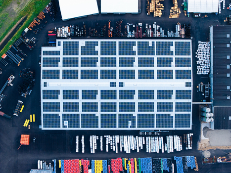 Aerial view of an industrial facility with solar panels on the roof and stored pipe systems in the yard in Jelgava Latvia. Aerial view of an industrial facility with solar panels on the roof and stored pipe systems in the yard in Jelgava Latvia.