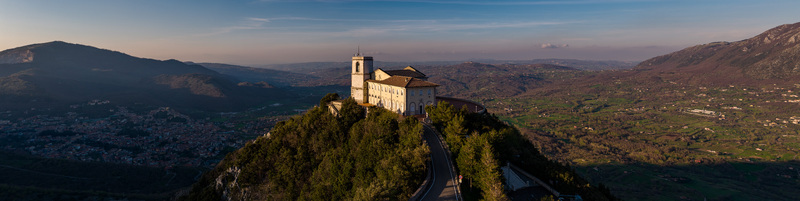 Aerial view of the Santuario del Santissimo Salvatore perched on a forested hilltop overlooking the valley and surrounding mountains in Montella Campania Italy. Aerial view of the Santuario del Santissimo Salvatore perched on a forested hilltop overlooking the valley and surrounding mountains in Montella Campania Italy.