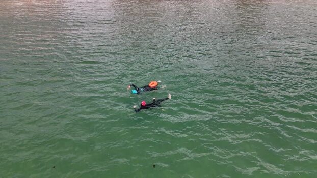 Aerial view of two swimmers in wetsuits in the sea Portugal.
