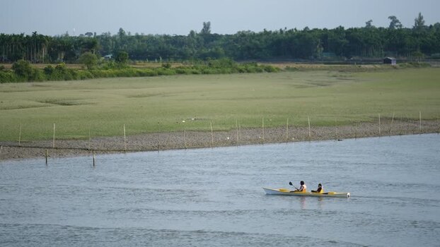 View of people rowing a boat on a river in Cox s Bazar Bangladesh.