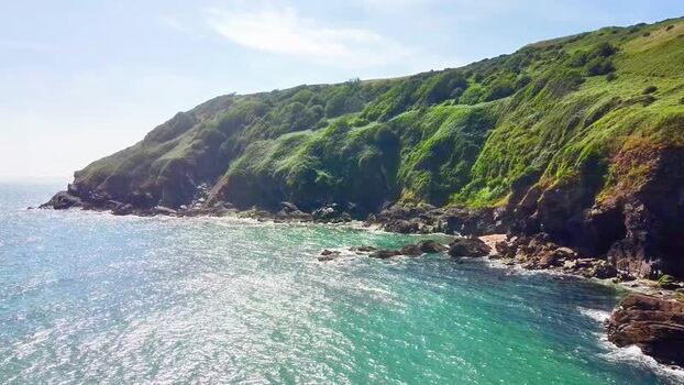 Aerial view of Lantic Bay cliffs and turquoise sea United Kingdom.