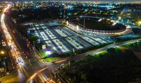 Aerial view of the Legon Sports Stadium at night featuring illuminated grandstands a large parking lot and surrounding city traffic lights in Accra Ghana. Aerial view of the Legon Sports Stadium at night featuring illuminated grandstands a large parking lot and surrounding city traffic lights in Accra Ghana.