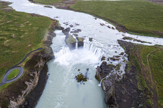 Aerial view of Godafoss Waterfall with cascading white water and rocky cliffs surrounded by green landscape Thingeyjarsveit Iceland. Aerial view of Godafoss Waterfall with cascading white water and rocky cliffs surrounded by green landscape Thingeyjarsveit Iceland.