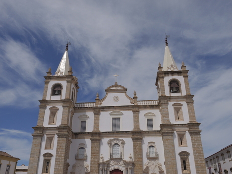 View of the facade of the historic Se de Portalegre cathedral with twin bell towers white walls and stone detailing under a blue sky in Portalegre Portalegre District Portugal.