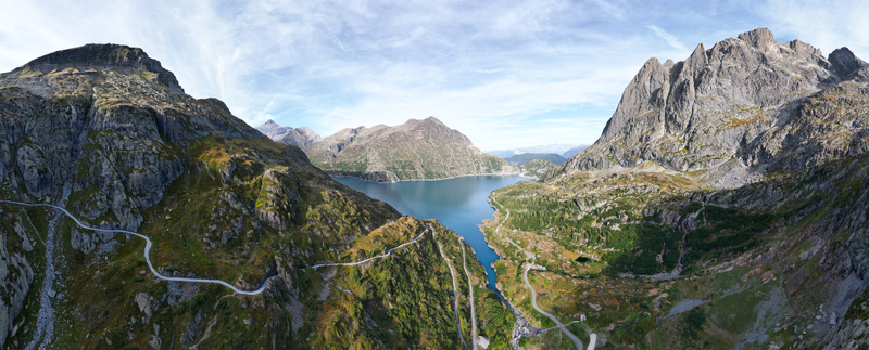 Aerial view of Barrage d Emosson surrounded by rugged alpine mountains winding mountain roads and deep blue water in Finhaut Valais Switzerland.