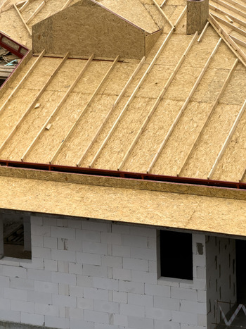 View of a house under construction showing wooden roof rafters and OSB sheathing on white concrete block walls in Sariyer Istanbul Turkiye.