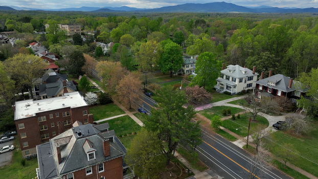 Aerial view of residential neighborhood with historic brick houses lush green trees in spring and winding streets in Lynchburg Virginia United States.