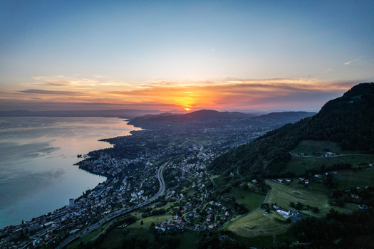 Aerial view of Glion overlooking Lake Geneva at sunset with the town of Montreux nestled along the shoreline in Montreux Vaud Switzerland. Aerial view of Glion overlooking Lake Geneva at sunset with the town of Montreux nestled along the shoreline in Montreux Vaud Switzerland.