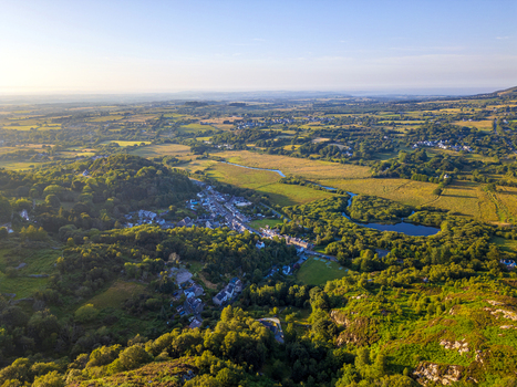 Aerial view of the village of Cwm y glo nestled among lush green hills a small lake and dense woodland during the golden hour in Cwm y glo Wales United Kingdom. Aerial view of the village of Cwm y glo nestled among lush green hills a small lake and dense woodland during the golden hour in Cwm y glo Wales United Kingdom.