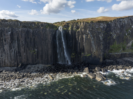 Aerial view of Mealt Falls cascading down dramatic basalt cliffs into the sea on the Isle of Skye Scotland United Kingdom. Aerial view of Mealt Falls cascading down dramatic basalt cliffs into the sea on the Isle of Skye Scotland United Kingdom.