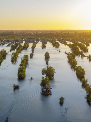 Aerial view of Scheendijk featuring small islands with houses and boats surrounded by calm water during golden hour in Breukelen Utrecht Netherlands. Aerial view of Scheendijk featuring small islands with houses and boats surrounded by calm water during golden hour in Breukelen Utrecht Netherlands.