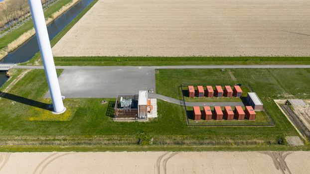 Aerial view of battery storage system at wind park with wind turbines