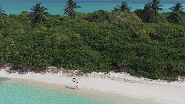 Aerial view of a person on a tropical beach in Maldives.