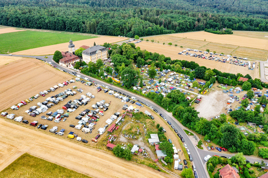 Eggolsheim Germany 09 May 2026 Aerial view of Schloss Jagersburg surrounded by lush trees a crowded parking lot with many vehicles and green fields under a bright sky. Eggolsheim Germany 09 May 2026 Aerial view of Schloss Jagersburg surrounded by lush trees a crowded parking lot with many vehicles and green fields under a bright sky.