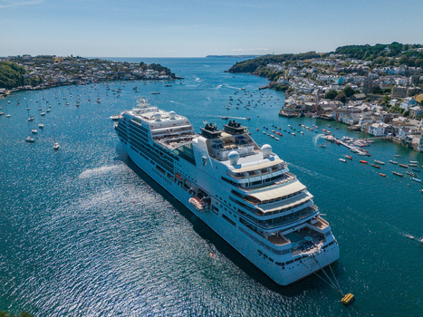 Fowey United Kingdom 10 August 2026 Aerial view of a cruise ship anchored in the Fowey River surrounded by small boats and the historic town of Fowey in Cornwall under a clear sky. Fowey United Kingdom 10 August 2026 Aerial view of a cruise ship anchored in the Fowey River surrounded by small boats and the historic town of Fowey in Cornwall under a clear sky.