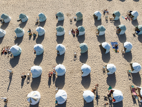 Figueira da Foz Portugal 08 August 2024 Aerial view of the Praia da Figueira da Foz beach featuring rows of striped tents and people relaxing on the sand under the summer sun. Figueira da Foz Portugal 08 August 2024 Aerial view of the Praia da Figueira da Foz beach featuring rows of striped tents and people relaxing on the sand under the summer sun.