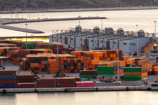 Aerial view of Ancona Port with stacks of colorful shipping containers industrial buildings and harbor infrastructure at sunset in Ancona Marche Italy. Aerial view of Ancona Port with stacks of colorful shipping containers industrial buildings and harbor infrastructure at sunset in Ancona Marche Italy.