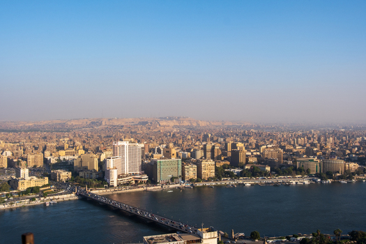 View of a sprawling cityscape with the Nile River flowing by bridges connecting vibrant districts under a clear sky Zamalek Cairo Governorate Egypt. View of a sprawling cityscape with the Nile River flowing by bridges connecting vibrant districts under a clear sky Zamalek Cairo Governorate Egypt.