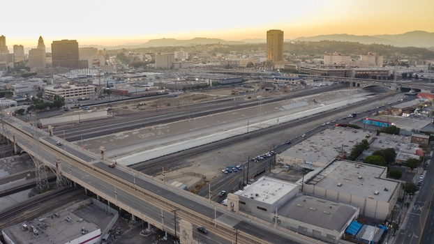 Aerial view of the Los Angeles River channel with bridges and railway tracks stretching towards the downtown skyline under a golden sunset in Los Angeles California United States. Aerial view of the Los Angeles River channel with bridges and railway tracks stretching towards the downtown skyline under a golden sunset in Los Angeles California United States.