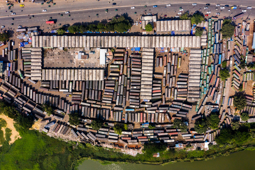 Aerial view of the dense rows of buses parked at the Gabtoli Bus Terminal with surrounding urban infrastructure and nearby water bodies in Dhaka Dhaka Division Bangladesh.