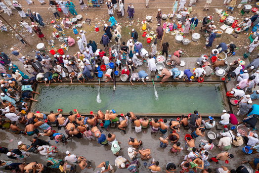 Tongi Dhaka Division Bangladesh 31 January 2025 Aerial view of Tongi Ijtema Maidan with people gathered around a water tank washing and preparing for prayer with cooking equipment.