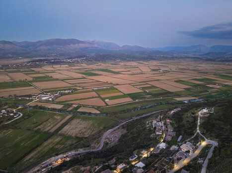 Aerial view of agricultural fields and rural landscape at dusk with mountains in the background near Saranda Vlore County Albania. Aerial view of agricultural fields and rural landscape at dusk with mountains in the background near Saranda Vlore County Albania.