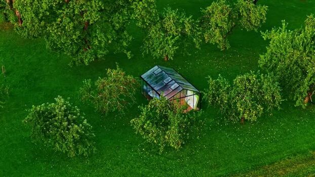 Aerial view of a glass greenhouse in a lush orchard Latvia. Aerial view of a glass greenhouse in a lush orchard Latvia.