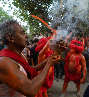 Munshiganj Bangladesh 13 April 2025 View of a devout man in vibrant red leading a smoky ritual amidst a reverent crowd vivid hues contrasting with ethereal smoke. Munshiganj Bangladesh 13 April 2025 View of a devout man in vibrant red leading a smoky ritual amidst a reverent crowd vivid hues contrasting with ethereal smoke.