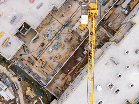 Aerial view of a construction site with a yellow tower crane concrete structures building materials and scaffolding in Gdansk Poland. Aerial view of a construction site with a yellow tower crane concrete structures building materials and scaffolding in Gdansk Poland.