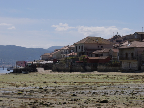 View of the historic fishing village of Combarro with traditional stone houses and granaries along the rocky waterfront at low tide in Combarro Pontevedra Spain.