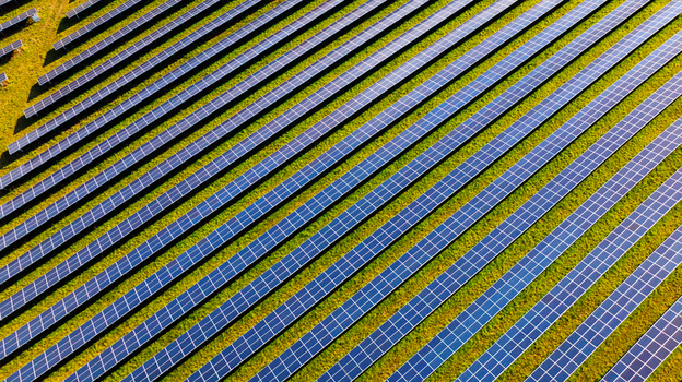 Aerial view of rows of solar panels installed in a green field under bright sunlight in Dorset England United Kingdom. Aerial view of rows of solar panels installed in a green field under bright sunlight in Dorset England United Kingdom.