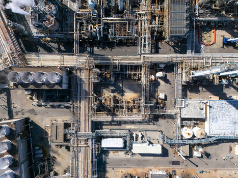 Aerial view of an industrial oil refinery complex featuring intricate piping networks large storage tanks and processing units in Carson California United States.